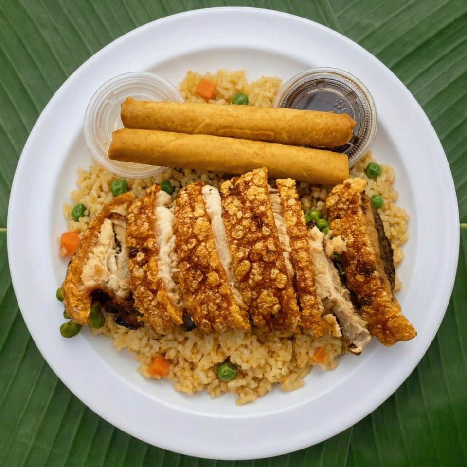 Crispy pork belly slices, fried rice with peas and carrots, two egg rolls, and dipping sauce.